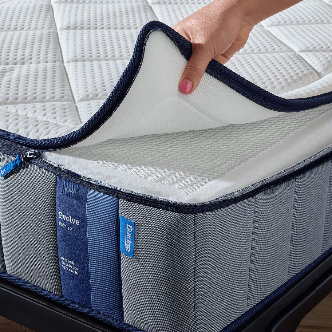 Hand maakt de hoes van de Auping Evolve matras los, de lagen worden zichtbaar