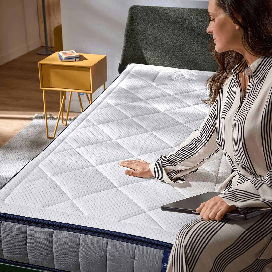 Vrouw voelt de Auping Evolve matras in een slaapkamer
